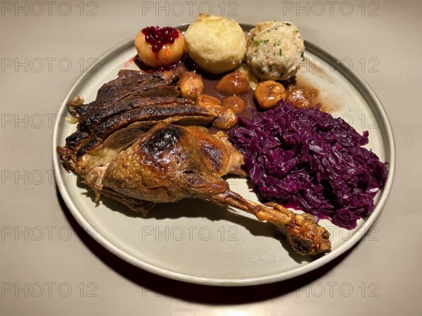 Plate with goose leg, goose breast, red cabbage, red cabbage, marenen, bread dumplings, raw potato