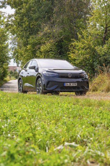 Black SUV on a green forest path surrounded by nature and trees, Cupra electric car, e-car sharing,