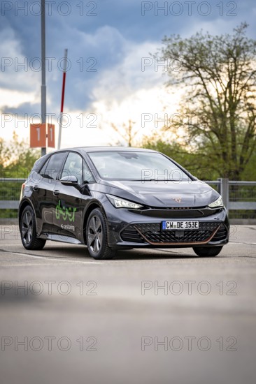 A Cupra vehicle is parked outside in front of a cloudy sky, gives a modern and stylish impression,