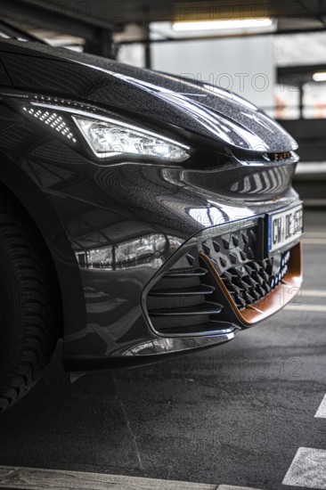 Close-up of a modern black car in underground garage with sporty design, Cupra electric car, e-car