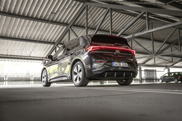 Modern black car in an urban parking garage from the rear view, Cupra electric car, e-car sharing,