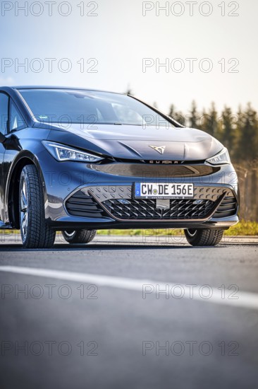 Close-up black car on a road with forest in the background, electric car Cupra, e-car sharing,
