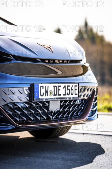 Close-up of the front of a modern black car with shiny body, electric car Cupra, e-car sharing,