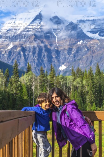 Mother and son are enjoying breathtaking views of mount robson, the highest peak in the canadian