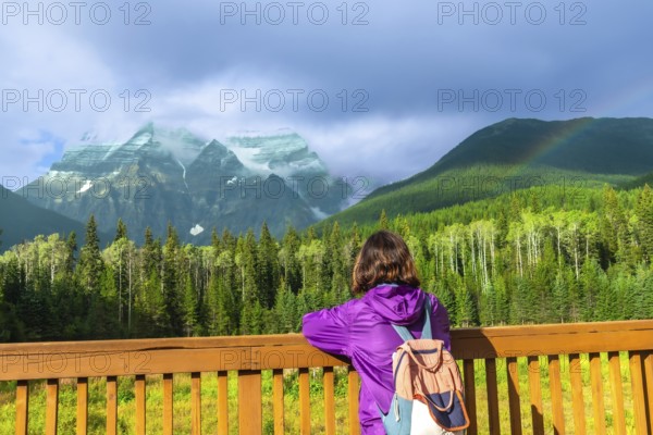 Female hiker with a backpack enjoying the breathtaking view of mount robson, the highest peak in
