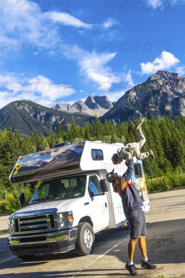 Father lifting his son in the air, celebrating their adventure in mount robson provincial park,