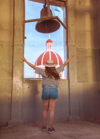 Travel woman spreading arms at viewpoint in Granada, Nicaragua Back view of tourist girl spreading