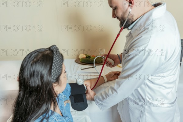 Nutritionist measuring blood pressure to patient. Measuring blood pressure to patient in the