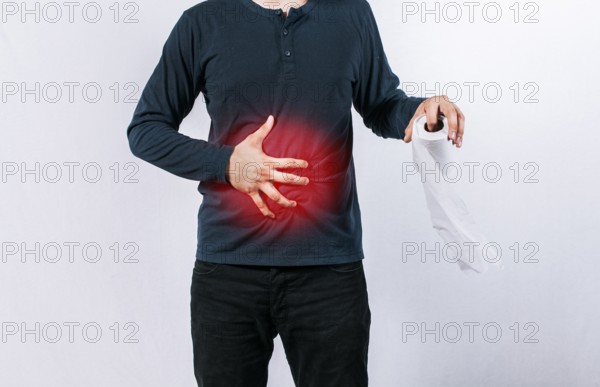 Man with stomach problems holding toilet paper, Person with toilet paper with stomach problems on