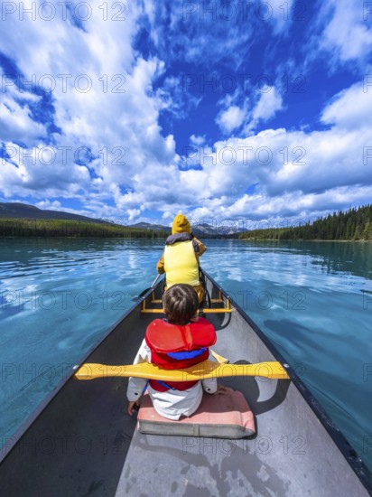 Tourists paddling a canoe on beautiful maligne lake in jasper national park, alberta, canada,