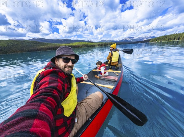 Family enjoying a sunny day canoeing on maligne lake in jasper national park, alberta, canada,