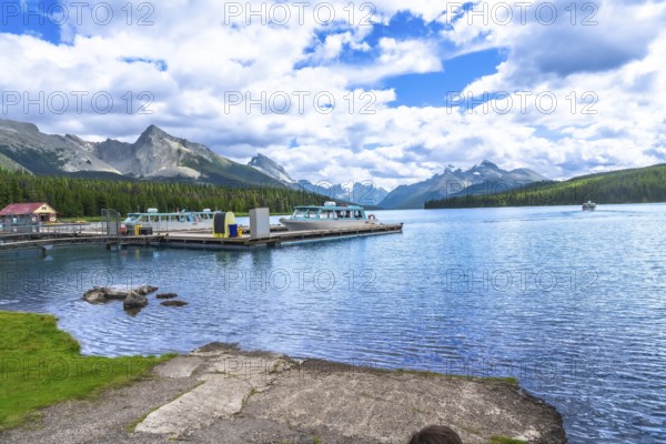 Tour boats are docked at maligne lake in jasper national park with a stunning view of the canadian