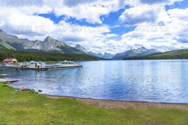Tranquil maligne lake in jasper national park reflecting the majestic canadian rockies, with boats