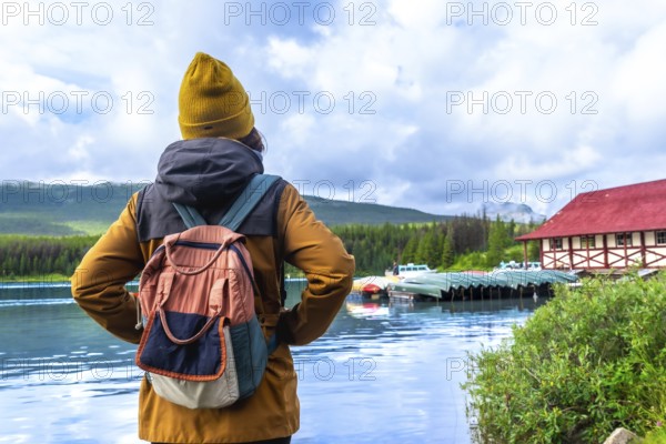 Female tourist with a backpack admiring the stunning view of maligne lake and its historic
