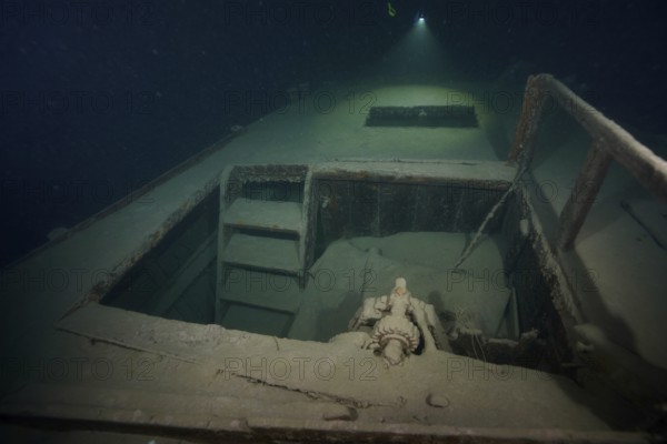 Diver examines a lediwreck, wreck of a lediship, ledi ship, cargo ship for mass freight, bulk