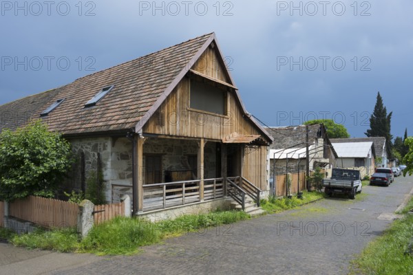 Rural scenery with wooden houses and parked cars under a cloudy sky, Schwabenstraße, village