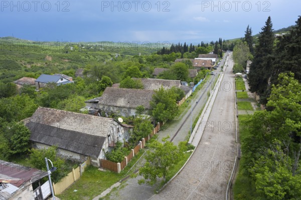 A quiet village with hills, wooded roads and scattered houses, view from the German Evangelical