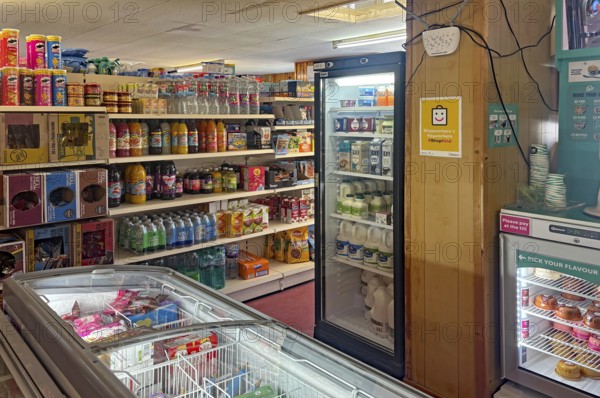 Small supermarket with fully stocked shelves and refrigerated products, shop on Westray Island,