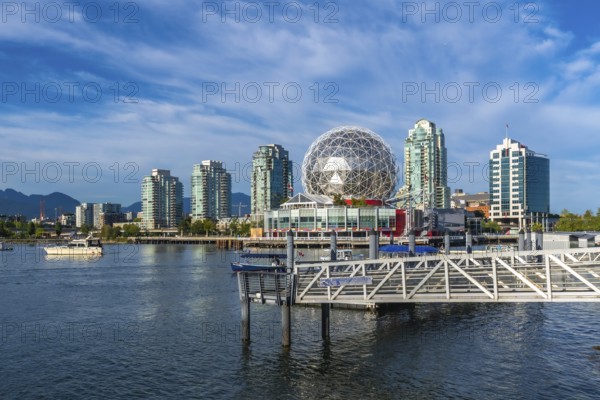 Modern buildings and science world are reflecting in the calm waters of false creek, vancouver,