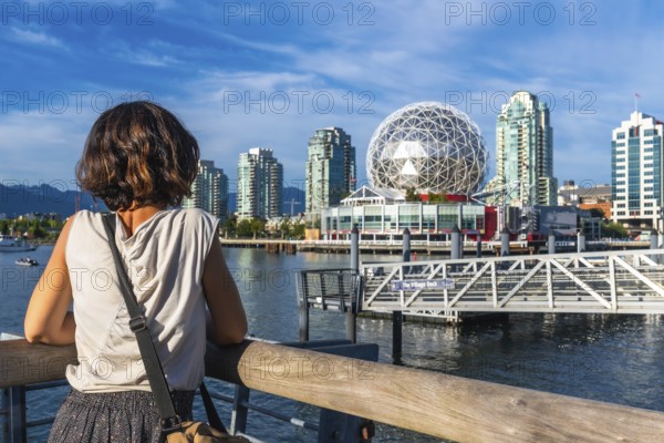 Young woman tourist is enjoying the cityscape of vancouver, british columbia, with science world