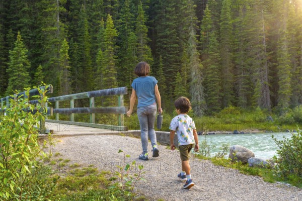 Mother and son enjoying a leisurely hike along a scenic banff national park trail, surrounded by
