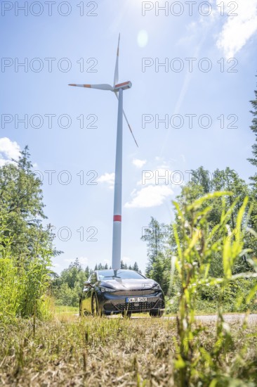 Car standing under a large wind turbine in sunny weather in a field, Deer E-Car Sharing, Cupra