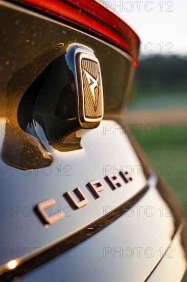 Close-up of emblem on black car with focus on details, Deer e-car sharing, Cupra electric car,
