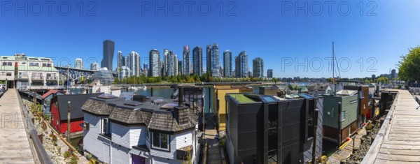 Panoramic view of colorful floating homes in false creek with modern and historical buildings of
