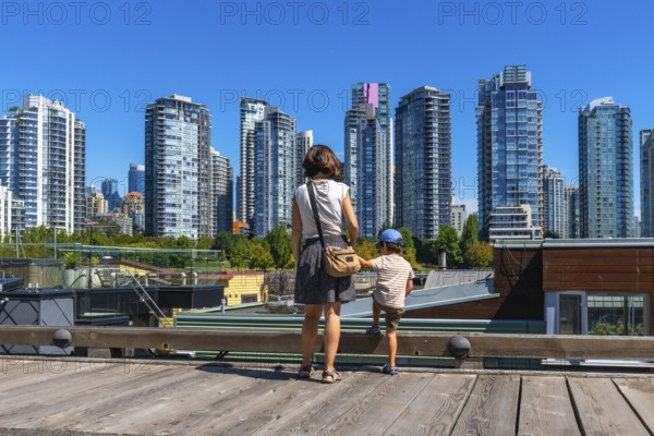 Mother and her son are enjoying the breathtaking view of the vancouver skyline, with its modern