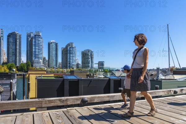 Mother and her son enjoying a sunny summer day walking along the wooden boardwalk of granville
