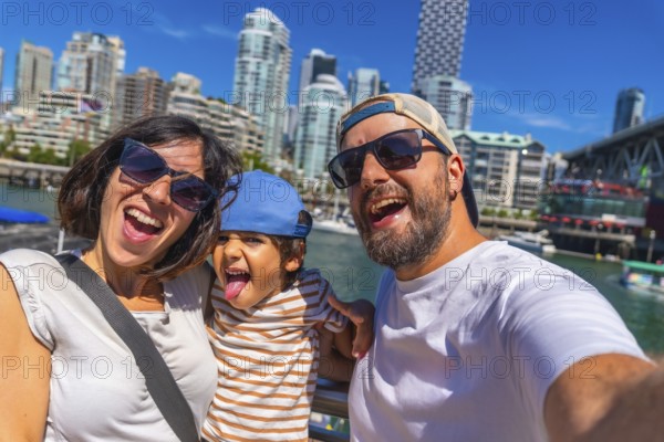 Happy family enjoying a sunny summer day while taking a selfie with the stunning vancouver, british