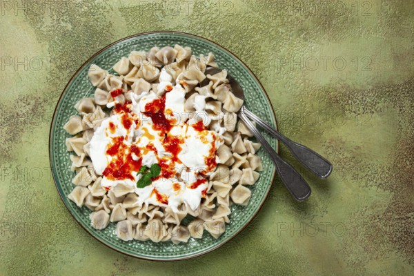 The dish features a generous serving of Turkish dumplings topped with velvety yogurt and a drizzle