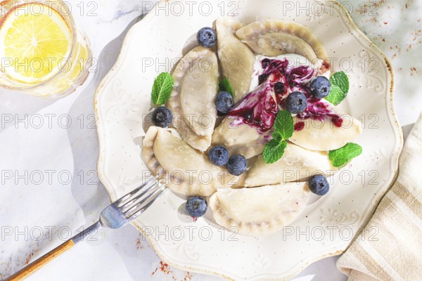 Handmade dumplings filled with sweet ingredients, arranged beautifully on a white plate, topped