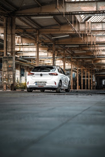 White car parked in empty industrial building, urban industrial look, deer e-car sharing,