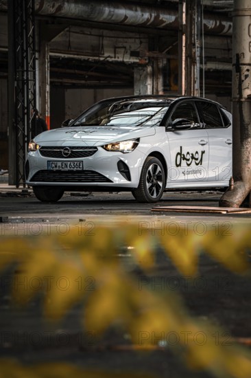 White Opel car sharing vehicle in industrial plant with yellow foreground, Deer E-Car Sharing,