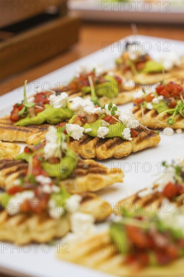 Fried gaufres with avocado and tomatoes on a white plate, Christmas party Dekra Congresshotel Wart,