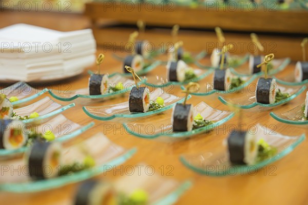 Sushi presentation on elegant glass plates for an exclusive buffet, Christmas party Dekra
