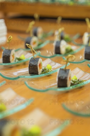 Small sushi appetizers artfully arranged on glass plates ready for reception, Christmas party Dekra