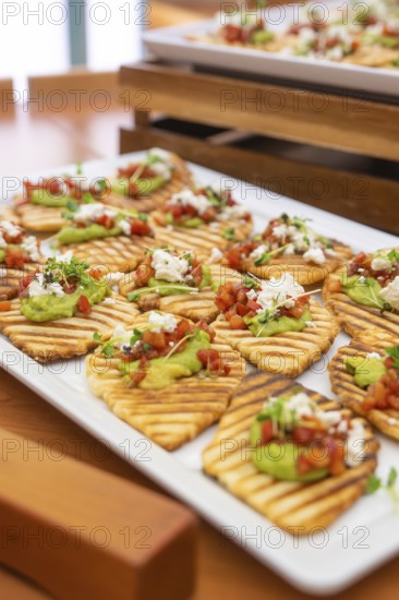 Creatively prepared tartines with guacamole and fresh garnish on wooden trays, Christmas party