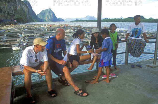 Young boy in the stilt village of Ko Pannyi in Phangnga Bay near Ko Phuket selling souvenirs to