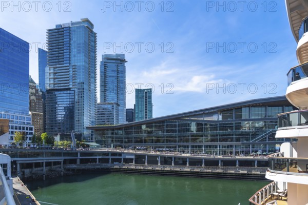 Glass skyscrapers and the vancouver convention centre are reflecting on the green water with a
