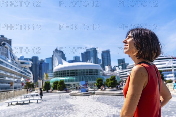 Happy tourist admiring the stunning vancouver downtown skyline, featuring cruise ships docked at