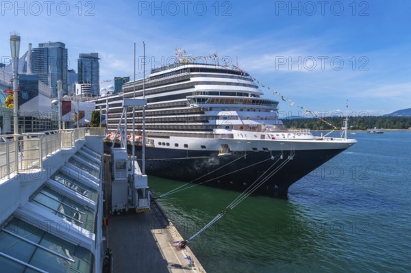 Large cruise ship docking at canada place cruise terminal in vancouver, british columbia, with city