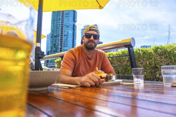 Tourist is having a burger and beer at an outdoor restaurant in vancouver, british columbia, with