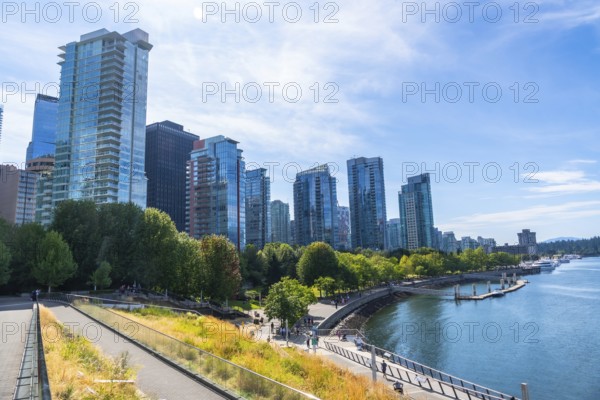 Vancouver's modern cityscape rises above a vibrant waterfront park, showcasing a blend of urban