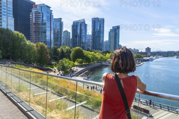 Tourist is enjoying the scenic view of vancouver skyline from david lam park in yaletown,