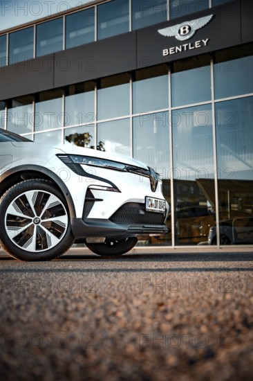 Car in front of a Bentley logo building, modern design and glass façade, Deer e-car sharing,