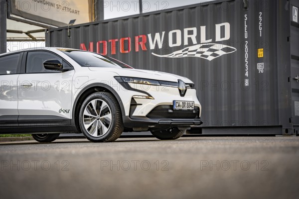 White electric car in front of a black container with Motorworld logo, Deer e-Carsharing, Renault