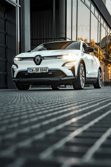 Renault car in front of reflecting windows at sunset in urban environment, Deer e-car sharing,