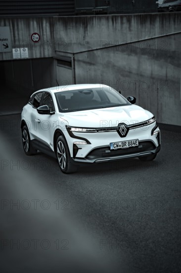 White modern SUV drives out of an underground car park on asphalt ground, Deer E-Carsharing,